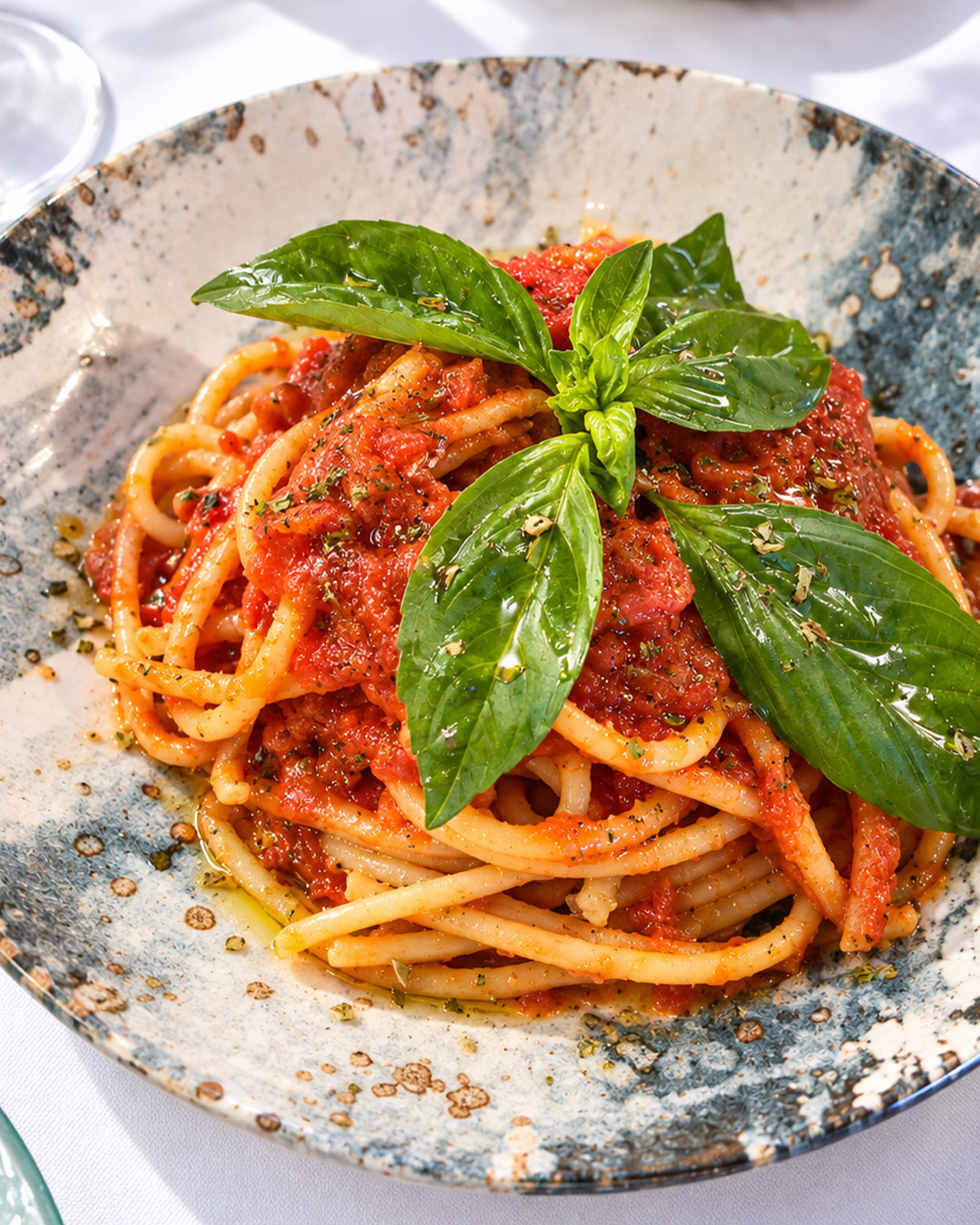 Bucatini all'amatriciana servis avec basilic frais