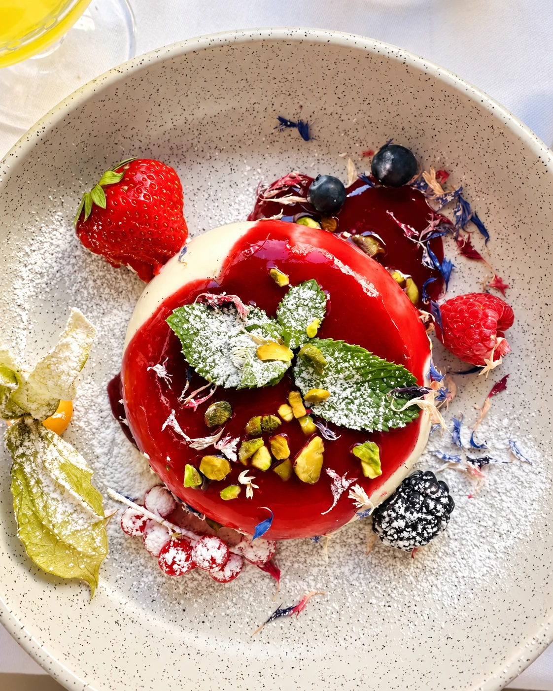 Dessert aux fruits rouges, pistaches et menthe dressé à l'assiette