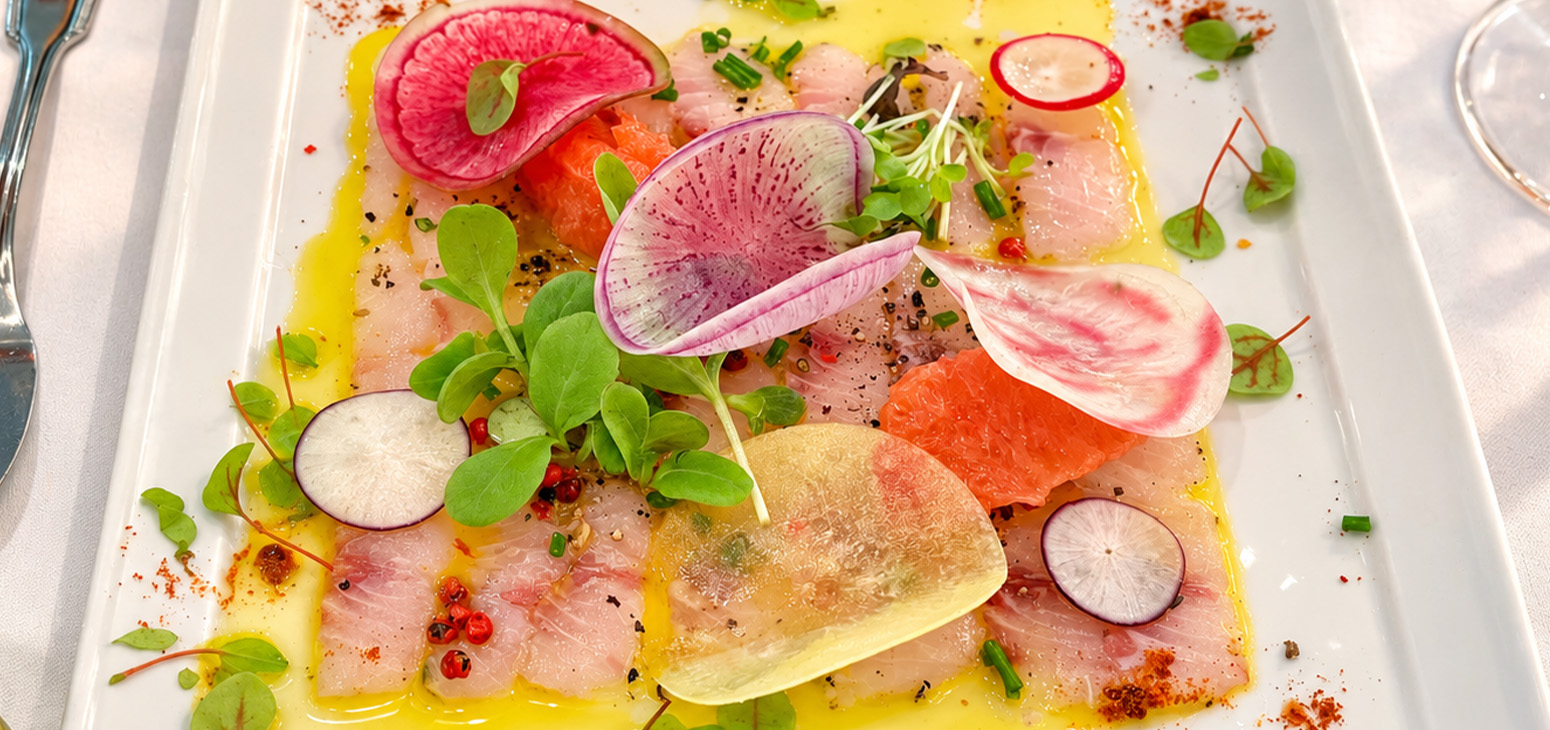 Assiette gastronomique de poisson cru, agrumes, radis et jeunes pousses